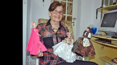 Gladys posa junto a tres de las muñecas que ella misma vistió. (LA OPINION)