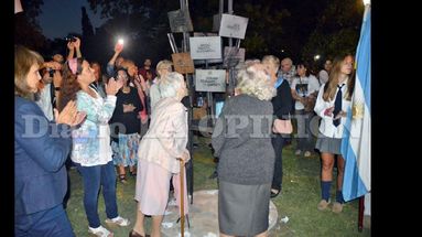 Alba Lanzillotto besa las placas de los desaparecidos en el monumento que fue inaugurado. (LA OPINION)