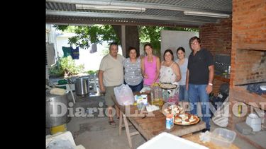 Un grupo de voluntarios elaboran cientos de viandas que son distribuidas entre los damnificados por la inundación. (LA OPINION)