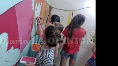 Manos a la obra: chicos trabajan en la pintura del mural. (LA OPINION)
