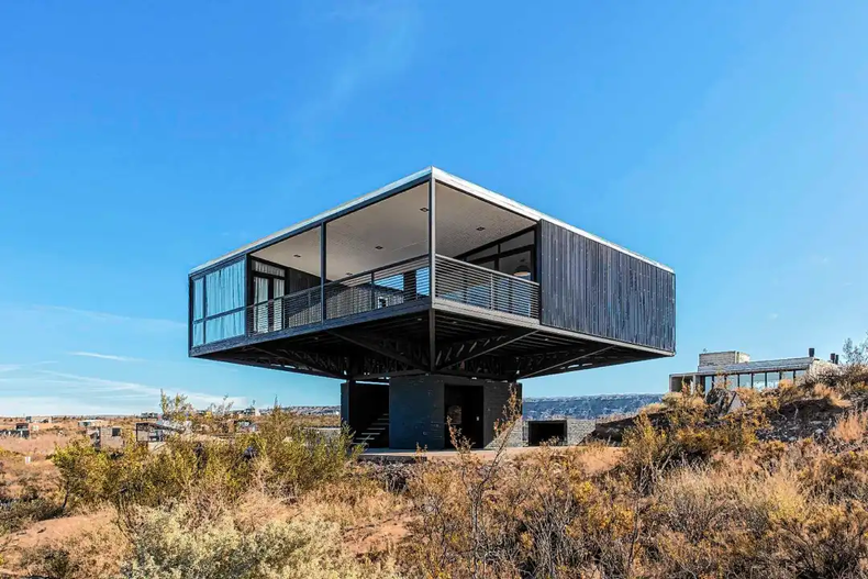 La vivienda está a 150 metros del embalse y un pequeño gran detalle la hace distinta a todas: apoyada en cuatro columnas centrales, está elevada tres metros en un lote con desnivel.