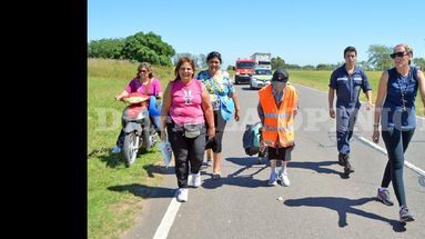 Emma Moroncini caminando por la ruta provincial Nº 178, acompañada por voluntarios. (LA OPINION)
