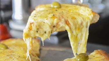 Queso desbordado y aceitunas: las marcas de la pizza argentina que nació en La Boca. Queso desbordado y aceitunas: las marcas de la pizza argentina que nació en La Boca.