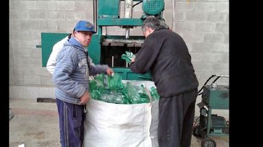 Los chicos que asisten al Taller Protegido colaboran con quien dirige la prensa hidráulica, proceso con el que se aplastan las botellas. (FACEBOOK TALLER PROTEGIDO PERGAMINO)