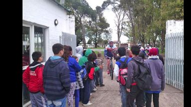 Los niños de los CDC, acompañados de funcionarios municipales, reciben a los ciclistas y entregan sus cartas en la Subsecretaría de Deporte.  (GOBIERNO DE PERGAMINO)