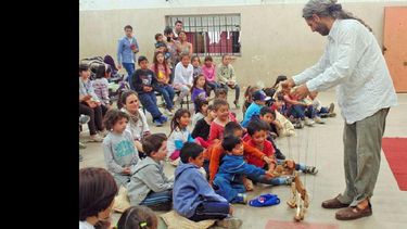El artista Hernán Lira, uno de los integrantes del Proyecto, junto a los niños del Centro del barrio 12 de Octubre. (GOBIERNO DE PERGAMINO)